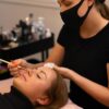 Eyelash extension procedure with master and a client in a beauty salon