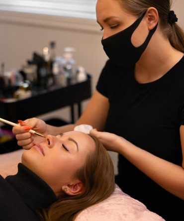 Eyelash extension procedure with master and a client in a beauty salon